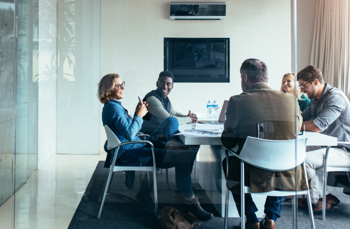 Employees around table discussing project-based accounting software