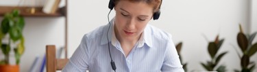 Woman doing eLearning with headphones on.